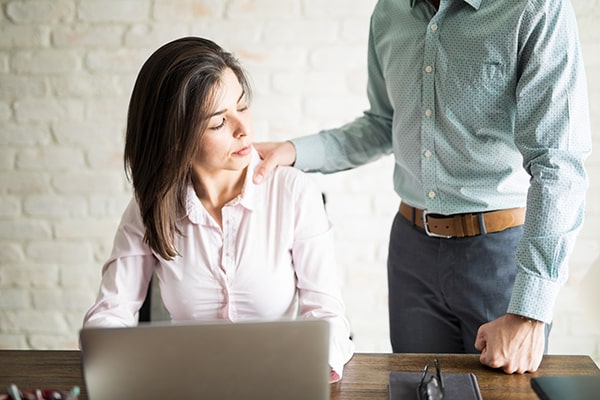 man touching woman's shoulder inappropriately